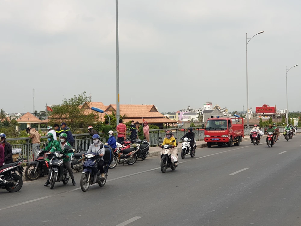 Nhiều người dân hiếu kỳ theo dõi lực lượng chức năng tìm kiếm nạn nhân. Ảnh: NT