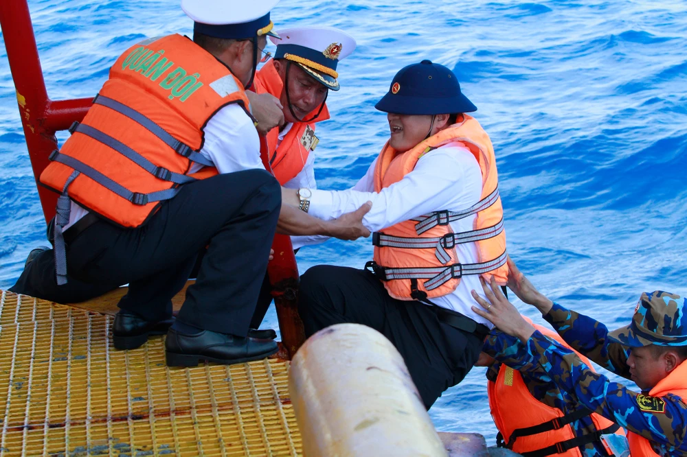 Lực lượng trên Nhà giàn DKI/14 và lực lượng thuộc tàu KN-290 phía dưới xuồng phải hiệp đồng một cách chính xác, đầy kinh nghiệm để đưa hơn 100 người thuộc đoàn công tác cùng số lượng hàng hóa khá nhiều lên trên. Ảnh: NT