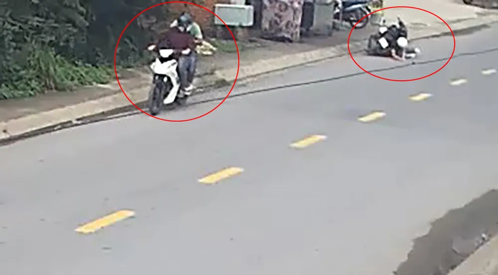 Cú giật mạnh khiến chị P té ngã xuống đường, bị xe máy đè lên người. Ảnh cắt từ clip