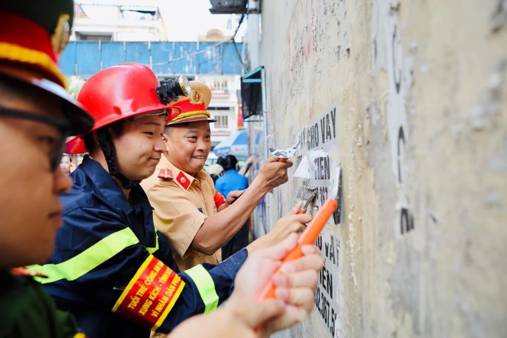 Đoàn Công an TP.HCM cũng phối hợp với các đơn vị ra quân bóc gỡ quảng cáo sai quy định trên nhiều địa bàn TP. Ảnh: CA