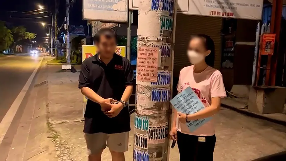 Công an phát hiện hai người nhận dán quảng cáo thuê với giá 28 ngàn đồng/100 tờ. Ảnh: CA