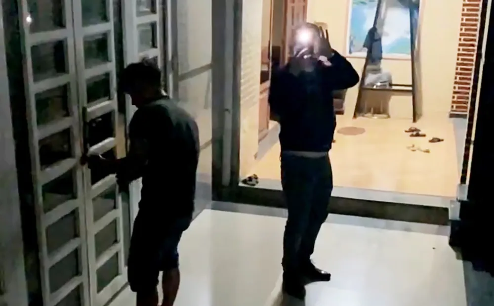 Những người lạ mặt tới phá khóa căn nhà trên địa bàn xã Phạm Văn Hai, huyện Bình Chánh. Ảnh cắt từ clip