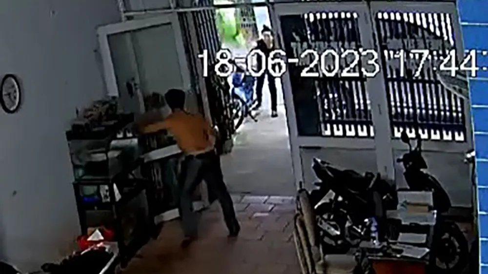 Nam thanh niên cầm ghế và gạch đá ném vào nhà của ông A. Ảnh cắt từ clip