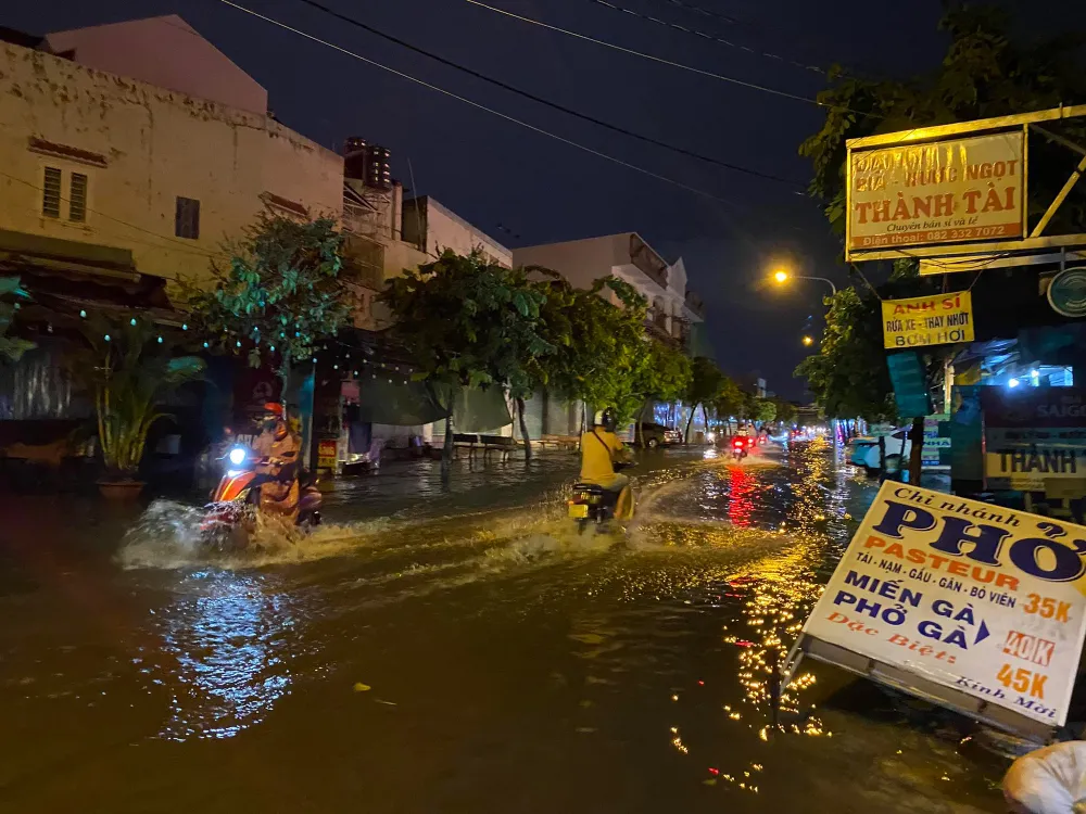Trên đường Song Hành, quận 12, mưa lớn cũng gây ngập; gió to khiến một bảng hiệu bị kéo đổ. Ảnh: HT