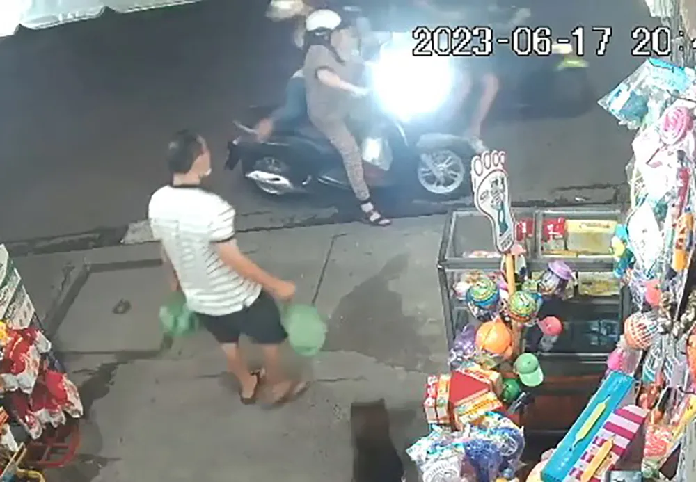 Chị T đang đứng chờ mua hàng thì bị hai thanh niên áp sát, cướp giật điện thoại. Ảnh cắt từ clip Chị T đang đứng chờ mua hàng thì bị hai thanh niên áp sát, cướp giật điện thoại. Ảnh cắt từ clip