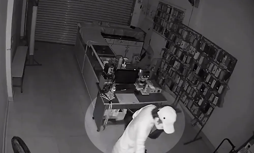 Người đàn ông đột nhập vào tiệm điện thoại trên địa bàn quận 12 lấy đi hàng chục điện thoại. Ảnh cắt từ clip