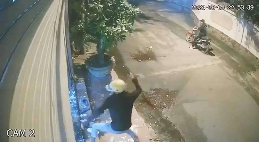 Nam thanh niên cầm dao tự chế chém cửa kính, cửa cuốn nhà anh T. Ảnh cắt từ clip