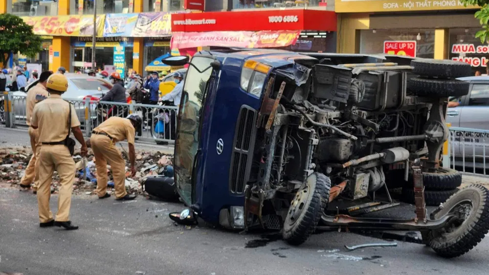 Chiếc xe ben đang lưu thông trên đường thì tông dải phân cách, lật đè trúng một xe máy. Ảnh: HT
