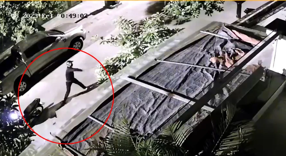 Trước đó, rạng sáng 12-8, một người đàn ông đi xe máy tới tạt sơn vào nhà anh T. Ảnh: Cắt từ clip