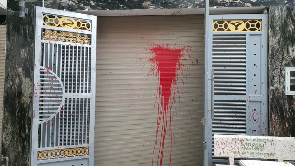 Sơn đỏ văng tung tóe khắp nơi trước nhà anh T. Ảnh: NT