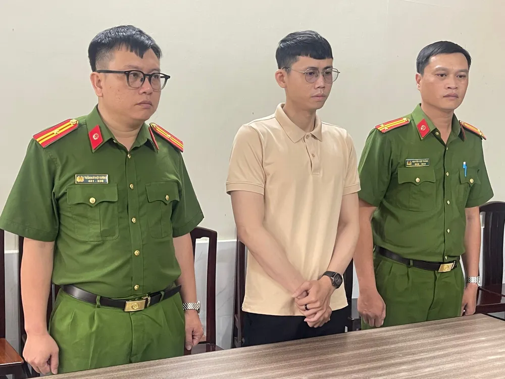 Hênh bị công an đọc lệnh bắt. Ảnh: CA truong-nhom-va-nhan-vien-tham-o-tai-san-cong-ty-dien-thoai-3.jpg