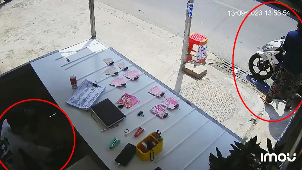 Trong lúc bà S đang tính tiền với người đi xe máy thì người đàn ông lẻn vào quầy, lấy trộm tài sản. Ảnh: Cắt từ clip dan-canh-mua-ve-so-lay-trom-220-to-ve-so-va-7-trieu-5.jpg