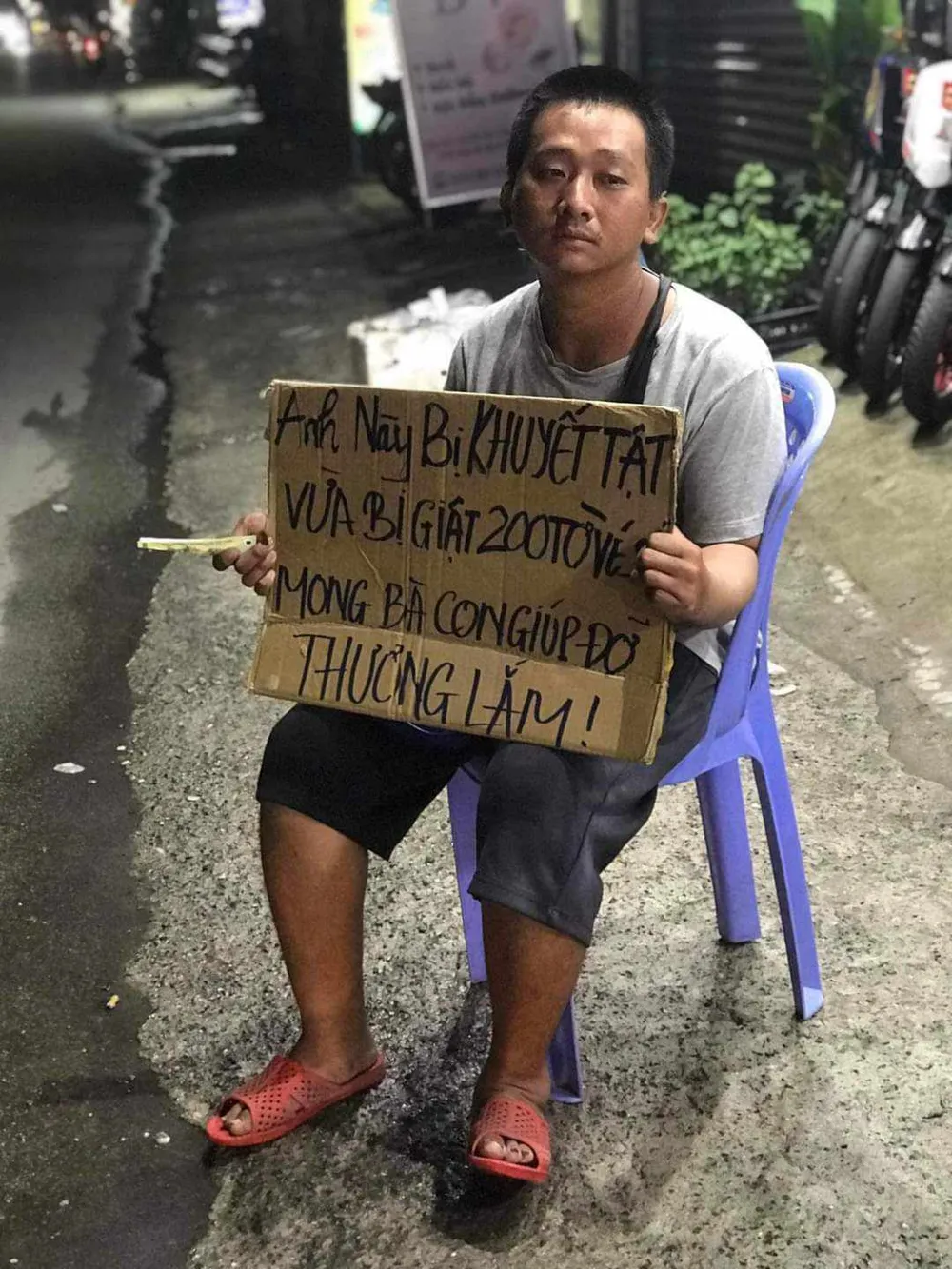 Người dân đã viết tấm bảng để anh Khoa cầm trên tay để ai đi qua biết chuyện thì ủng hộ. Ảnh: HT lam-ro-vu-thanh-nien-30-tuoi-bi-giat-200-to-ve-so.jpg