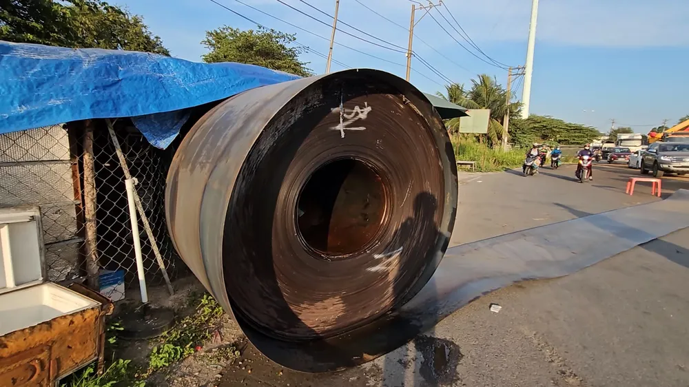 Một cuộn sắt rơi xuống đường, lăn hàng chục mét trúng vào nhà dân mới dừng lại. Ảnh: NT 3 cuộn sắt trên xe đầu kéo bị đứt xích giằng, rơi xuống Quốc lộ 1