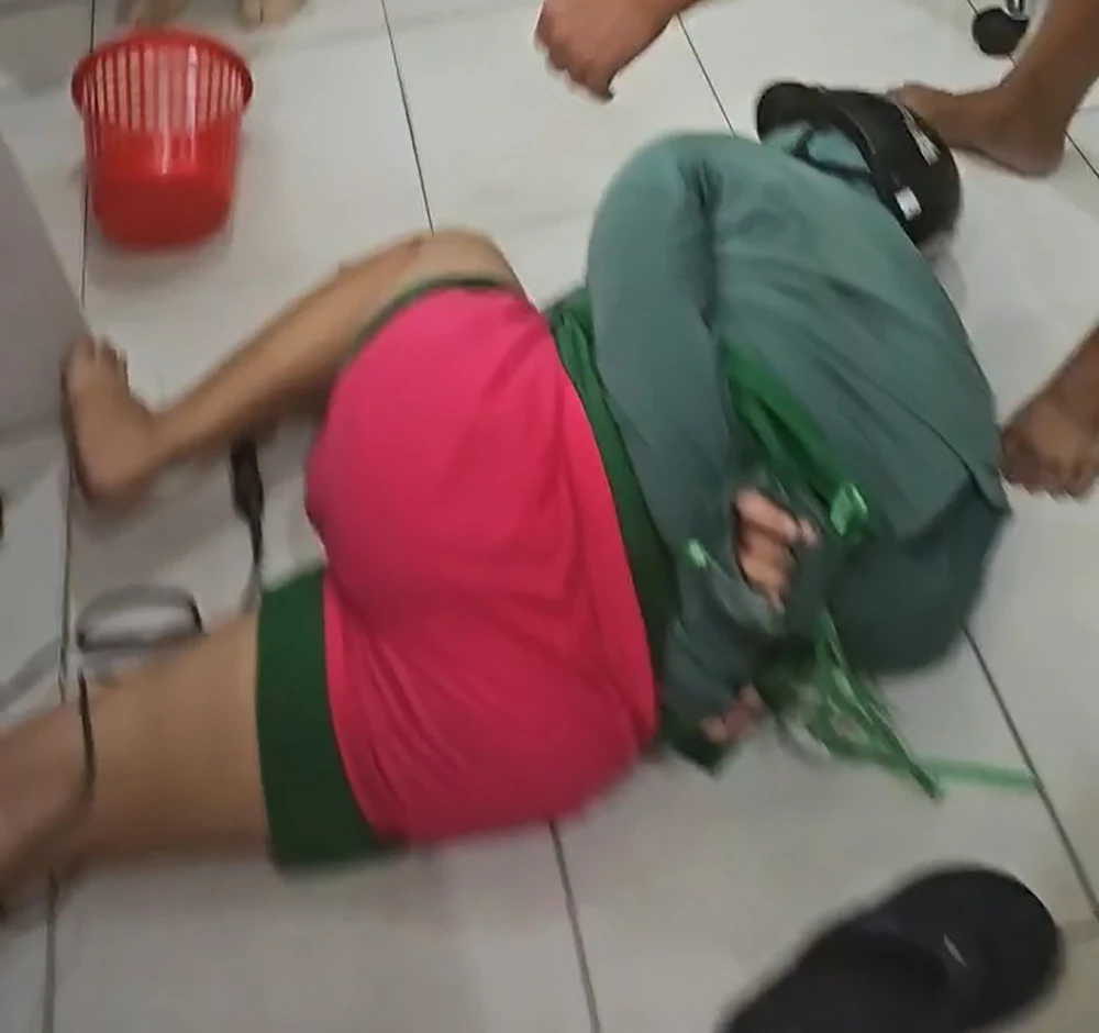 Người dân tham gia khống chế người phụ nữ, nghi phạm trong vụ việc. Ảnh: NT 1-phu-nu-cam-dao-cuop-cua-hang-f88-o-quan-12-2-3215.jpg