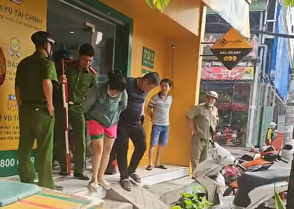 Người phụ nữ nhanh chóng bị công an đưa lên trụ sở để điều tra. Ảnh: NT 1-phu-nu-cam-dao-cuop-cua-hang-f88-o-quan-12-6531.jpg