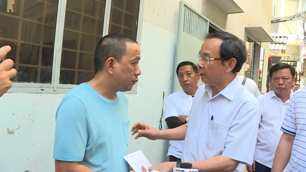 Bí thư Thành ủy TP.HCM Nguyễn Văn Nên trao tiền hỗ trợ cho ông Toàn. Ảnh: HT Vụ cháy 3 nhà chết 4 người: Hàng xóm nghi 1 nạn nhân phóng hỏa
