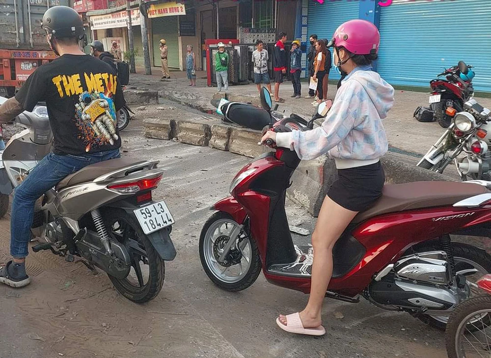 Xe container đang lưu thông qua ngã tư Trung Chánh thì tông dải phân cách bê tông, văng trúng xe máy. Ảnh: Quang Sơn Container tông dải phân cách bê tông văng trúng 2 xe máy ở ngã tư Trung Chánh