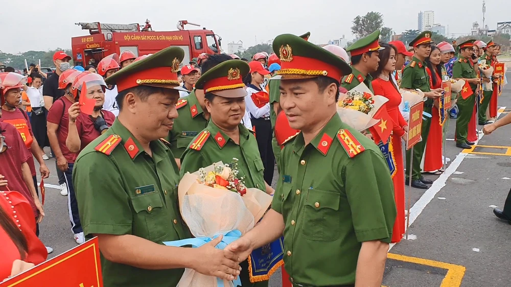 Đại tá Phạm Đình Ngọc, Trưởng Công an quận 12 tặng hoa, chúc mừng các đơn vị tham gia tại hội thi. Ảnh: NT 12-to-lien-gia-an-toan-pccc-lan-dau-tranh-tai-o-hoi-thi-cap-quan-1.jpg