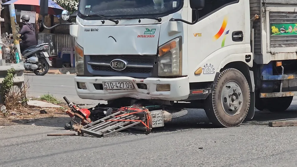 Chiếc xe máy hư hỏng nặng, nằm trước đầu xe tải. Ảnh: HT Chạy xe máy đi sửa, người đàn ông bị xe tải tông tử vong ở Bình Chánh
