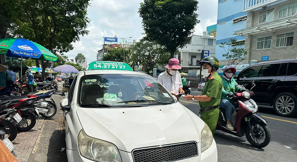 Đội CSGT-TT, Công an quận 3 tuần tra, xử lý việc dừng đỗ sai quy định với một tài xế xe taxi 27-7 ở trước cổng Bệnh viện Tai Mũi Họng. Ảnh: YT Công an tuần tra, các ‘xe taxi tráo tiền’ ở quận 1, quận 3 “vắng bóng”