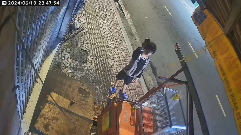 Bé trai đưa chiếc điện thoại lên hướng camera an ninh như để nói với chủ tiệm. Ảnh cắt từ clip Bé trai hành động đẹp giấu giúp điện thoại nhưng lại bị 1 người lớn lấy đi