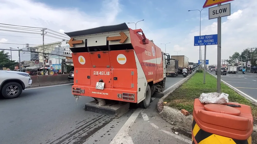 Trong trưa ngày 28-6, các công nhân Công ty cổ phần Công trình cầu phà TP.HCM cũng dùng phương tiện quét dọn khu vực có xuất hiện "đinh tặc". Ảnh: NT Đi vài bước đã nhặt được gần 100 mảnh đinh ở cầu vượt An Sương