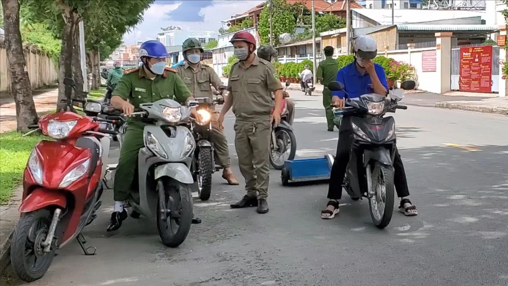 Trưa ngày 29-6, Công an và Đoàn Thanh niên phường Trung Mỹ Tây đã kéo xe hút đinh dọc Quốc lộ 1. Ảnh: NT Công an, Đoàn thanh niên cùng kéo xe hút đinh ở cầu vượt An Sương