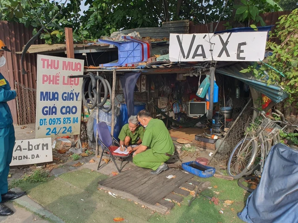 Công an phường Trung Mỹ Tây cho ký cam kết với chủ các tiệm sửa xe không rải đinh "bẫy" người đi đường. Ảnh: NT cong-an-doan-thanh-nien-cung-keo-xe-hut-dinh-o-cau-vuot-an-suong-9.jpg