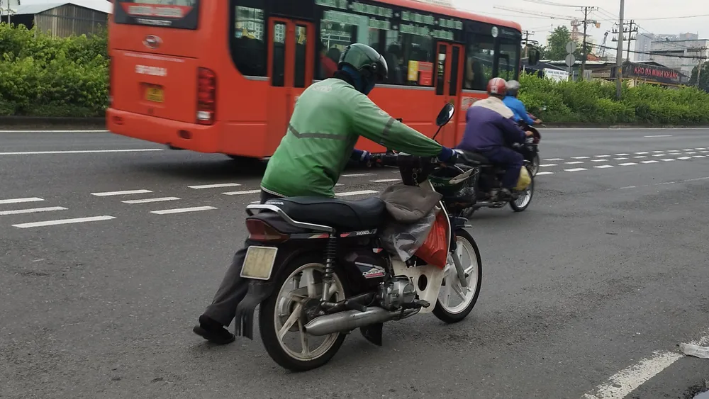 Tài xế xe ôm công nghệ cho biết phải bỏ cuốc xe giữa chừng vì bánh xe bị lủng khi vừa lên khỏi đoạn dốc từ hầm cầu vượt Linh Xuân về hướng cầu vượt Sóng Thần. Ảnh: NHẬT TRUNG Tối hút sạch, sáng ‘đinh tặc’ lại xuất hiện ở cầu vượt Linh Xuân
