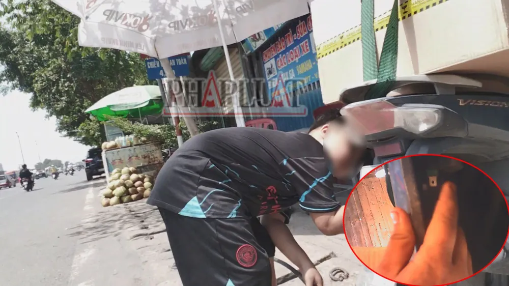 Con trai ông Đông ra bơm xe nhưng lại rút sợi dây mobin sườn của khách. Ảnh: NHÓM PV Bài 4: Cận cảnh người lớn phối hợp trẻ con phá xe trên Quốc lộ 51