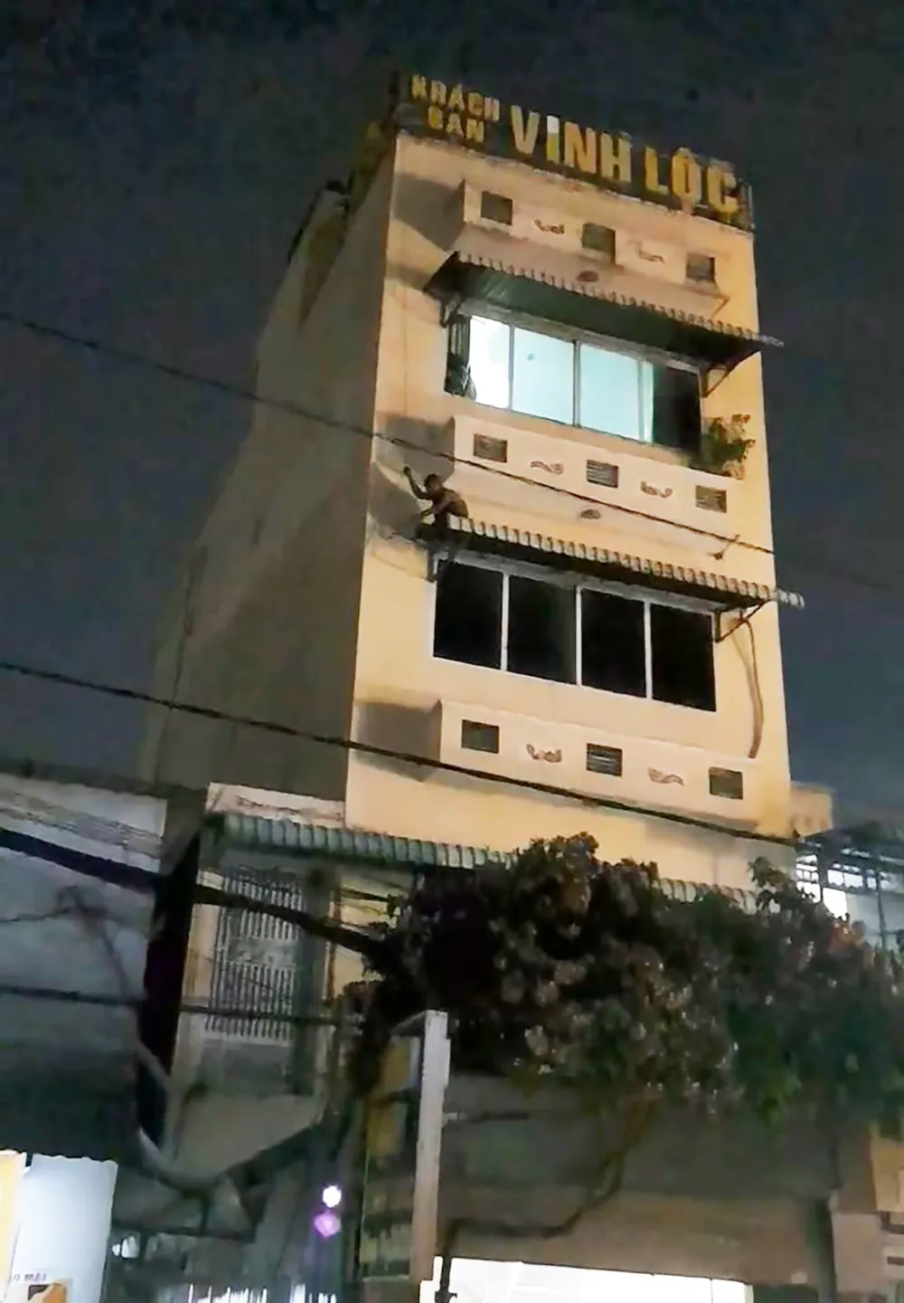 Người này sau đó đu dây, leo qua mái nhà dân. Ảnh: HT Thanh niên nghi ngáo đá, đu dây ở tầng 3 khách sạn như “người nhện”