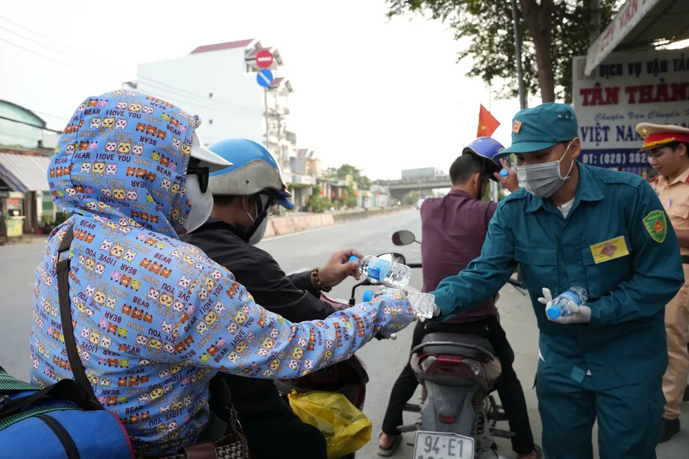 Hàng trăm người dân về quê nghỉ lễ được tặng nón bảo hiểm, nước suối ở Bình Chánh