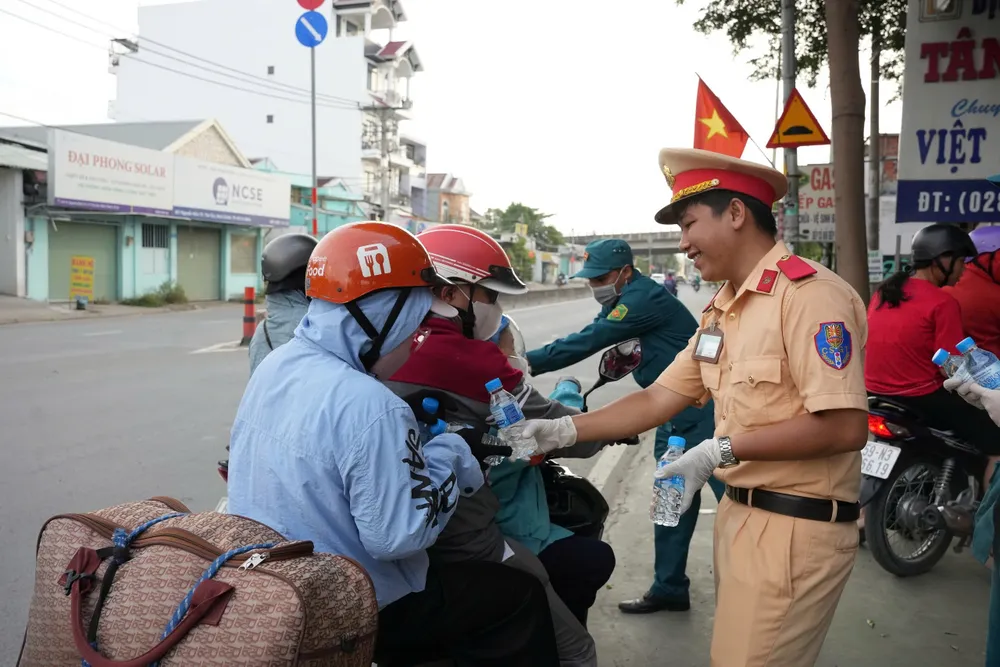 Hàng trăm người dân về quê nghỉ lễ được tặng nón bảo hiểm, nước suối ở Bình Chánh