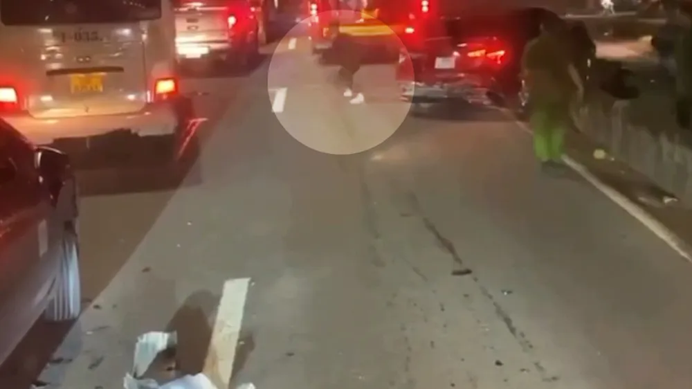 Một người trên xe ô tô bung cửa tẩu thoát. Ảnh cắt từ clip Ô tô ‘điên’ chở thuốc lá lậu tông hàng loạt xe để tẩu thoát trên Quốc lộ 22