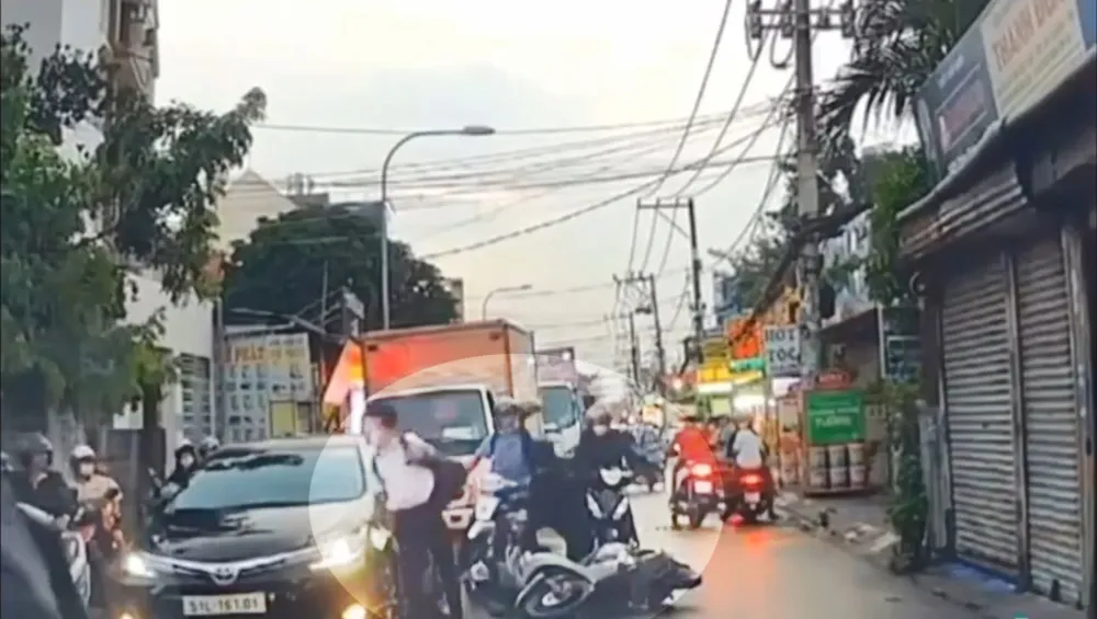 Sau khi bị té, một nam sinh bỏ chạy, người còn lại bị thanh niên đánh đập. Ảnh cắt từ clip nhom-nguoi-ep-xe-danh-hoc-sinh-giua-duong-o-quan-12-la-ai-5.jpg