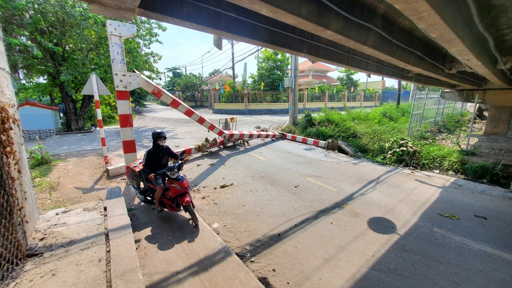 Khung giới hạn chiều cao bị tông ngã, chắn ngang đường khiến xe máy đi lại khó khăn. Ảnh: NT Khung giới hạn chiều cao dạ cầu Xáng thường xuyên bị phá hoại, công an đang truy tìm thủ phạm