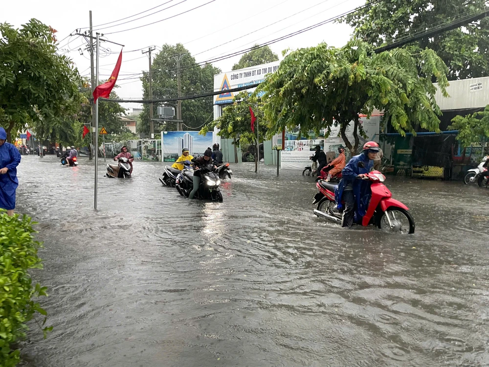 Nhiều xe chết máy phải dắt bộ trên đường Song Hành, quận 12. Ảnh: NT mua-lon-sang-som-nhieu-tuyen-duong-tp-hcm-ngap-nang-4.jpg