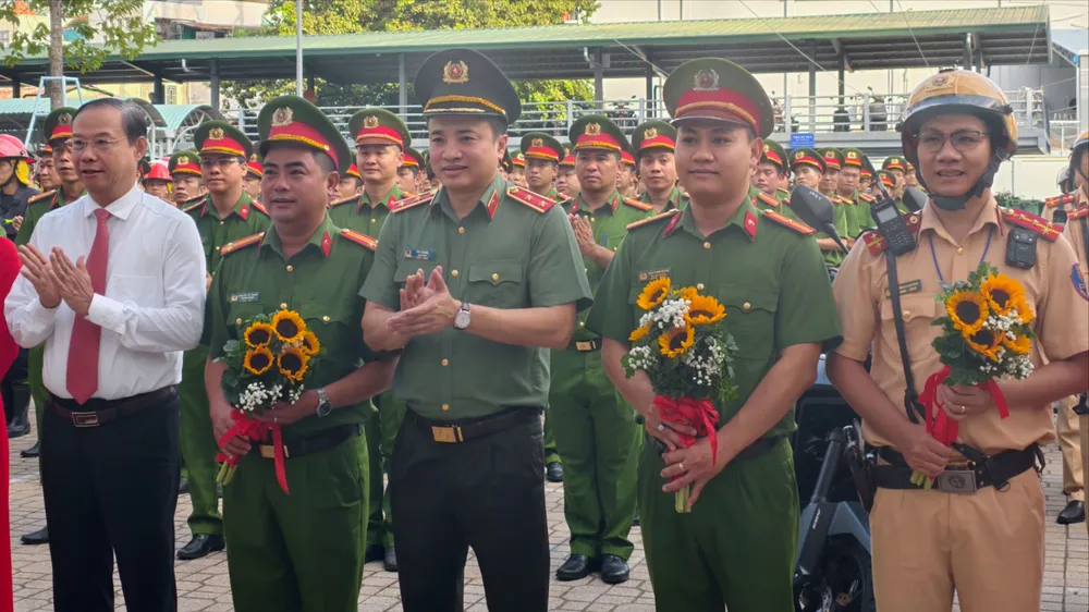 Lãnh đạo UBND TP.HCM và Công an TP.HCM tặng hoa cho các đơn vị trong lễ ra quân. Ảnh: NGUYỄN TÂN giam-doc-cong-an-tp-hcm-phat-lenh-tong-ra-quan-tran-ap-cac-loai-toi-pham-21.jpg