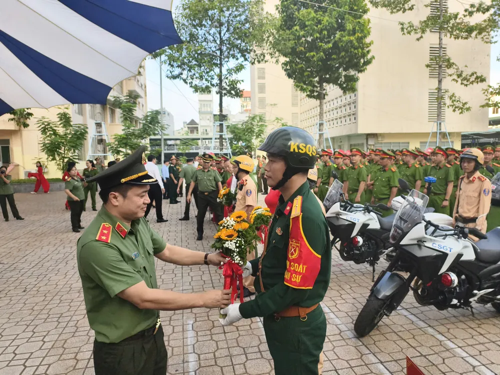 Trung tướng Mai Hoàng, Giám đốc Công an TP.HCM, tặng hoa cho các đơn vị tham gia lễ ra quân. Ảnh: NGUYỄN TÂN giam-doc-cong-an-tp-hcm-phat-lenh-tong-ra-quan-tran-ap-cac-loai-toi-pham-4.jpg