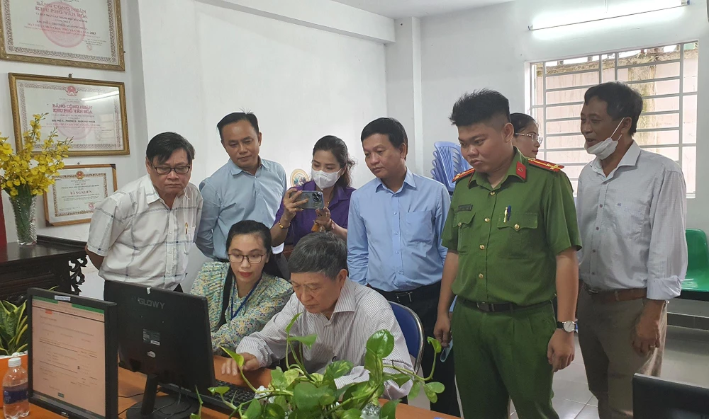 Các lãnh đạo quận Phú Nhuận tham quan điểm làm thủ tục hành chính trực tuyến tại chung cư 43, phường 9, quận Phú Nhuận. Ảnh: NGUYỄN YÊN