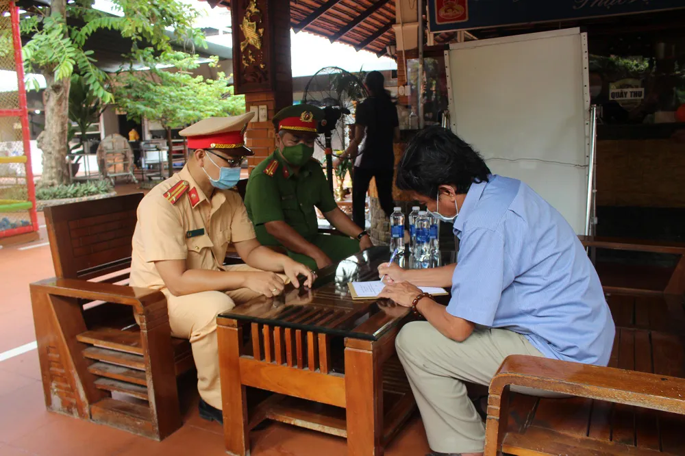 Chủ nhà hàng ký cam kết với CSGT. Ảnh: NGUYỄN YÊN