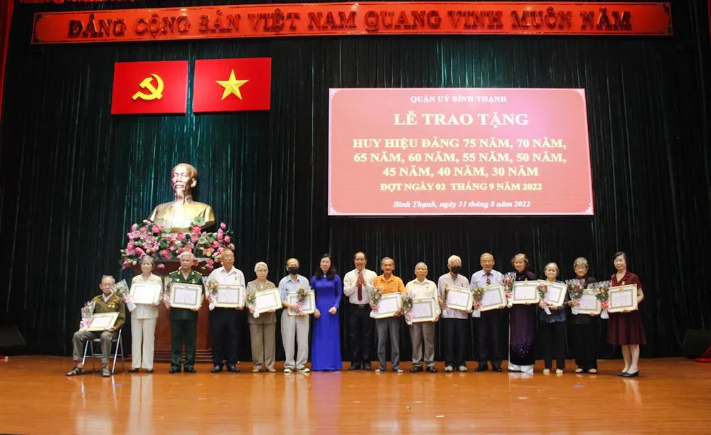 Bà Triệu Lệ Khánh, Phó Bí thư thường trực Quận uỷ Bình Thạnh trao tặng huy hiệu Đảng cho các Đảng viên. Ảnh: NGUYỄN YÊN