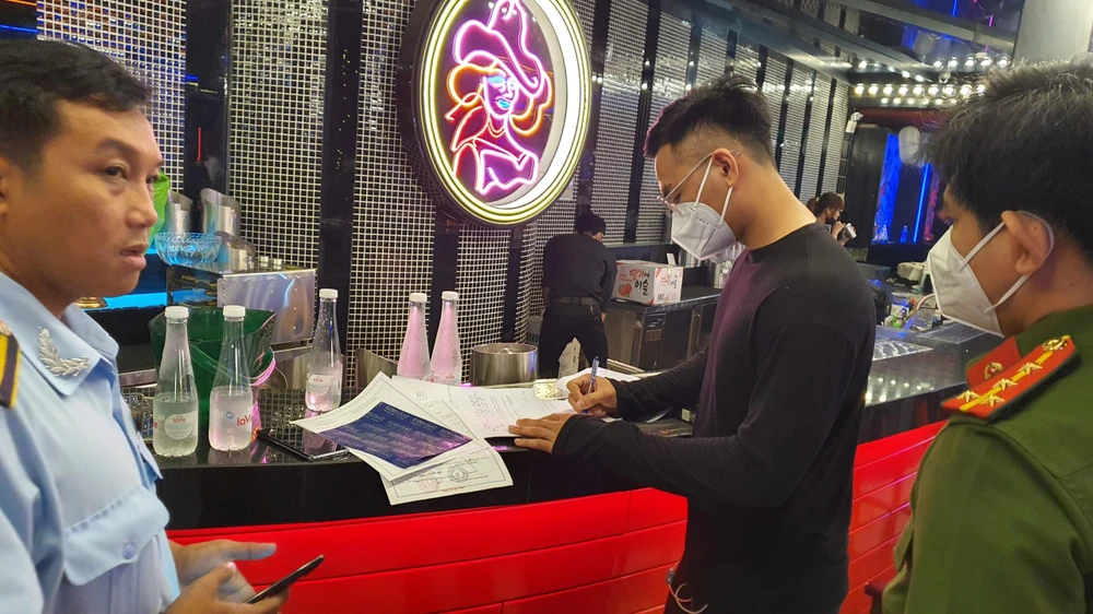 Đại diện quán ký biên bản vi phạm do lực lượng chức năng lập vào tối 5-10. Ảnh: NGUYỄN YÊN