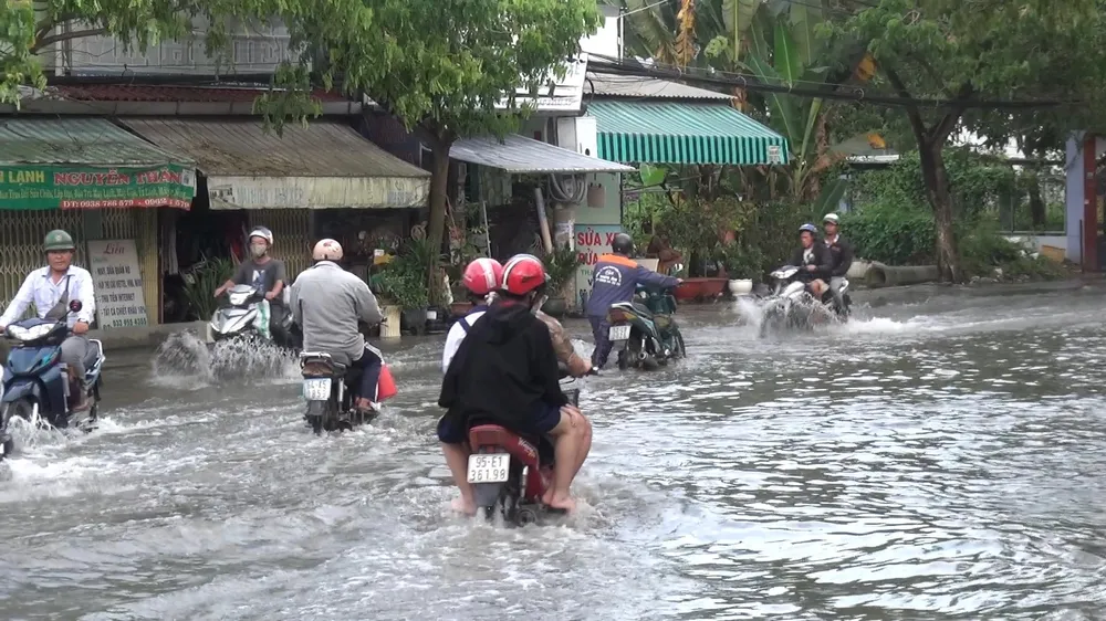 Người dân di chuyển vất vả trong nước lớn do triều cường. Ảnh: ĐC