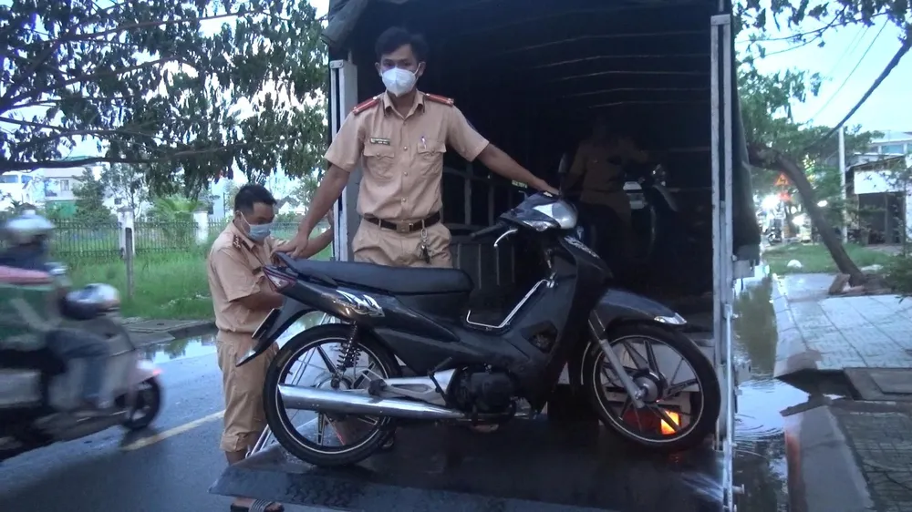 Đưa xe người dân lên xe tải để vượt qua đoạn nước ngập. Ảnh: ĐC