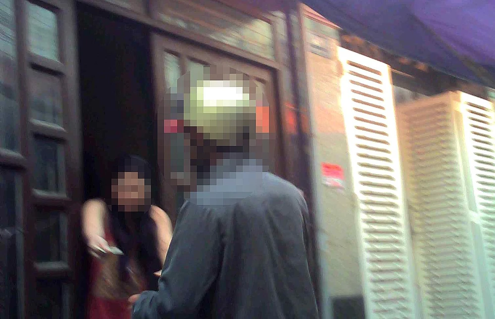 Người phụ nữ đứng trong nhà đưa ma túy ra ngoài bán cho khách tại hẻm trên đường Lương Ngọc Quyến, quận Gò Vấp. Ảnh: TY