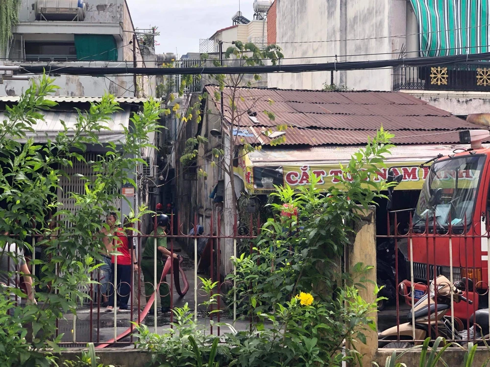 Nối ống từ đầu hẻm vào khu vực đang cháy để dập lửa. Ảnh: ĐC