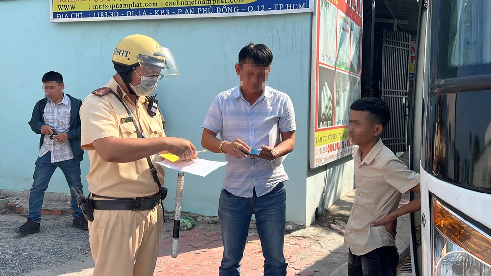 CSGT kiểm tra giấy tờ đối với một xe khách. Ảnh: NGUYỄN YÊN