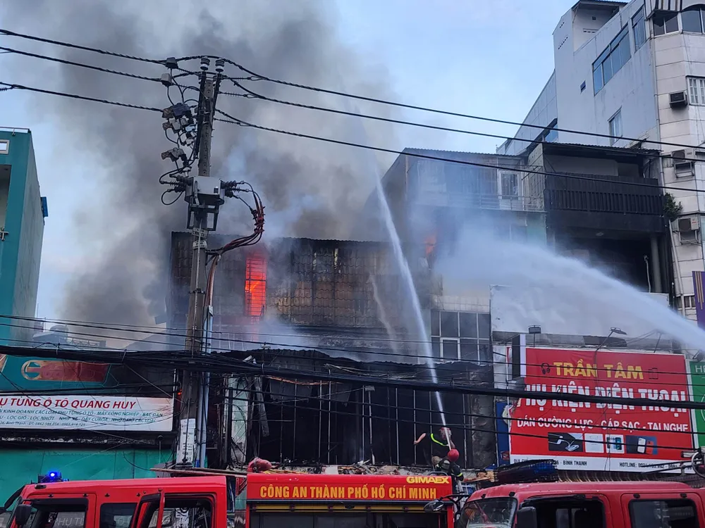 Đám cháy lan sang hai cửa hàng bên cạnh. Ảnh: ĐC Đám cháy lan sang hai cửa hàng bên cạnh. Ảnh: ĐC